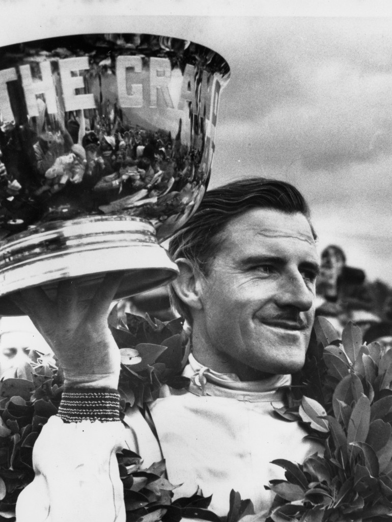 Graham Hill of England, holds aloft the victor’s silver bowl
