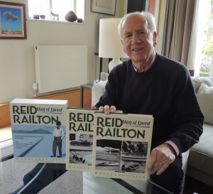 Photo of Karl Ludvigsen sitting at a table with three books on Reid Railton: Man of Speed in front of him.