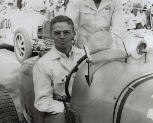 Black and white photo of Cameron Argetsinger in 1948 sitting behind the wheel of a race car.