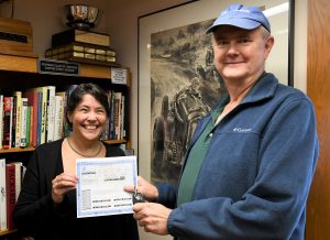 Head archivist Jenny Ambrose, with winner Lee Apostale, holds the Porsche title and car keys. 